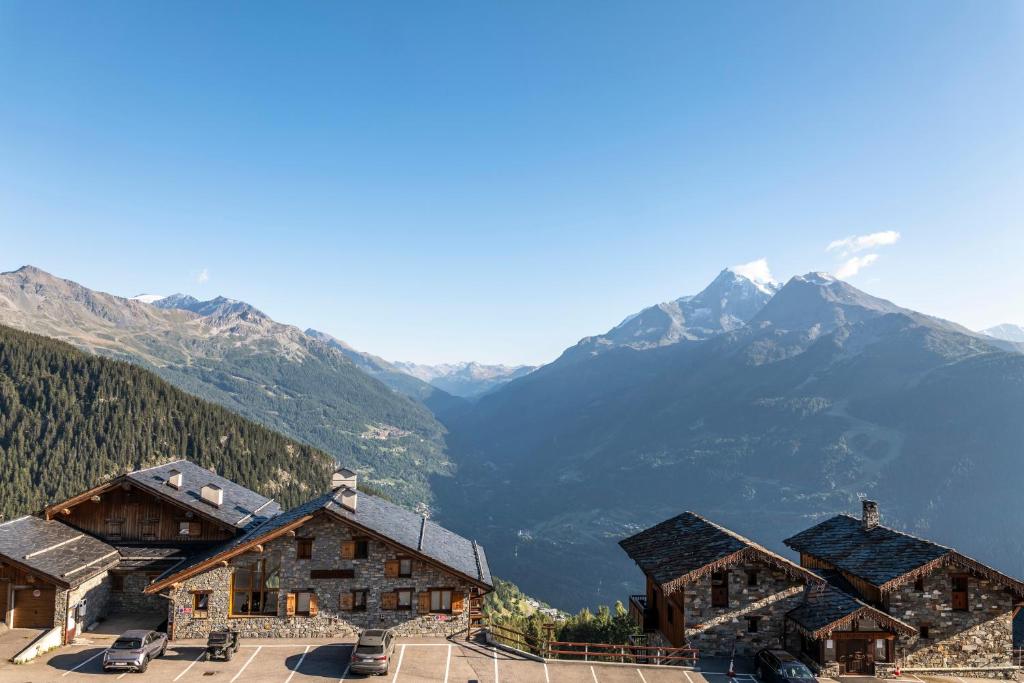 un groupe de bâtiments avec des montagnes en arrière-plan dans l'établissement MGM Hôtels & Résidences - Résidence Alpen Lodge, à La Rosière