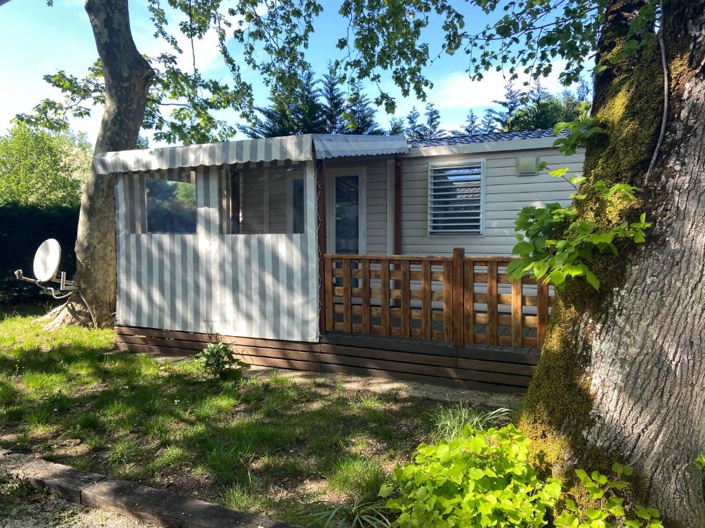 une petite maison avec une clôture et un arbre dans l'établissement Mobilhome 516, à La Teste-de-Buch