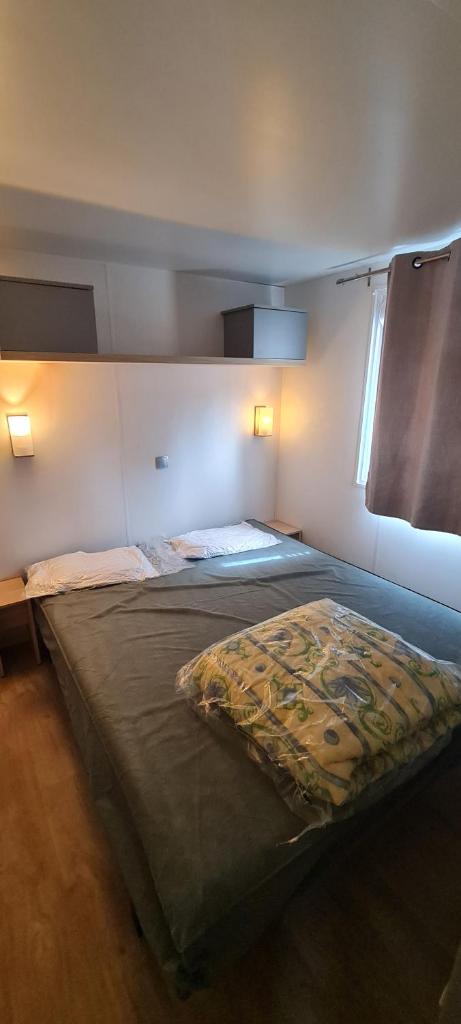 une chambre avec un grand lit dans une pièce dans l'établissement MOBILHOME PREMIUM 3CH 6PERS, à Nans-les-Pins