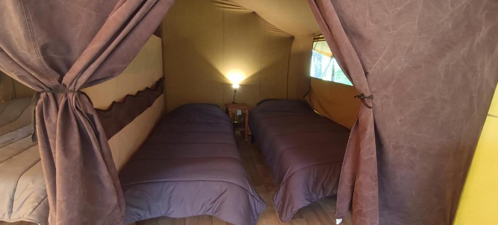 une chambre avec deux lits dans une tente dans l'établissement Tente safari au Pont du Gard, à Vers-Pont-du-Gard