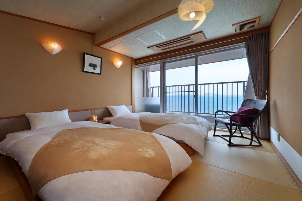 - 2 lits dans une chambre d'hôtel avec balcon dans l'établissement Ako Onsen Shokichi, à Ako