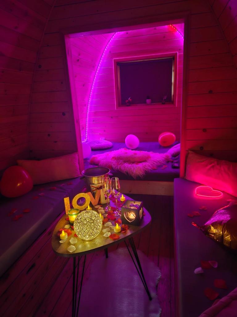une chambre violette avec une table. dans l'établissement Magnifique Pod avec spa sous bulle privatif, à Lanthenay