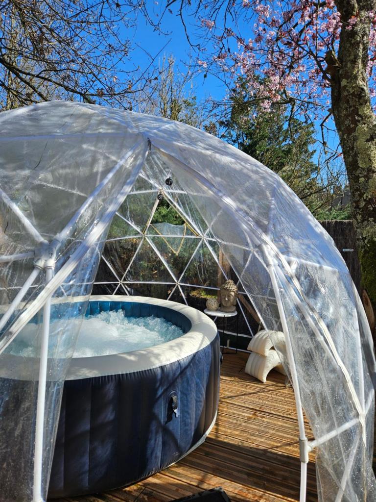 - un bain à remous dans une tente en forme de dôme sur une terrasse dans l'établissement Magnifique Pod avec spa sous bulle privatif, à Lanthenay