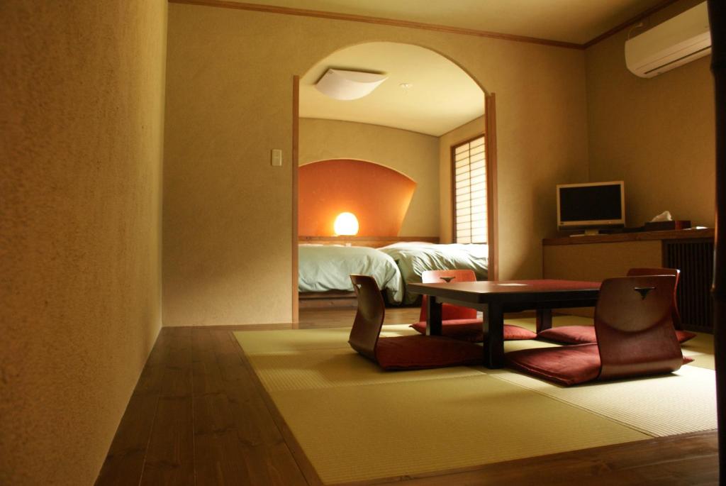 une chambre avec un lit, une table et des chaises dans l'établissement Super Hydrogen Rich Spa Yado Kanzan, à Minakami