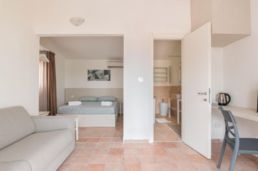 un salon avec un canapé et un lit dans l'établissement Q Resort, à Marina di Sorso