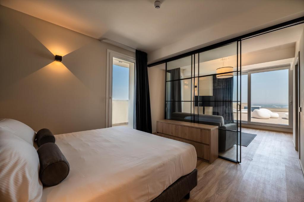 - une chambre avec un grand lit et un mur en verre dans l'établissement Hotel Sporting Riccione, à Riccione 85 autres photos