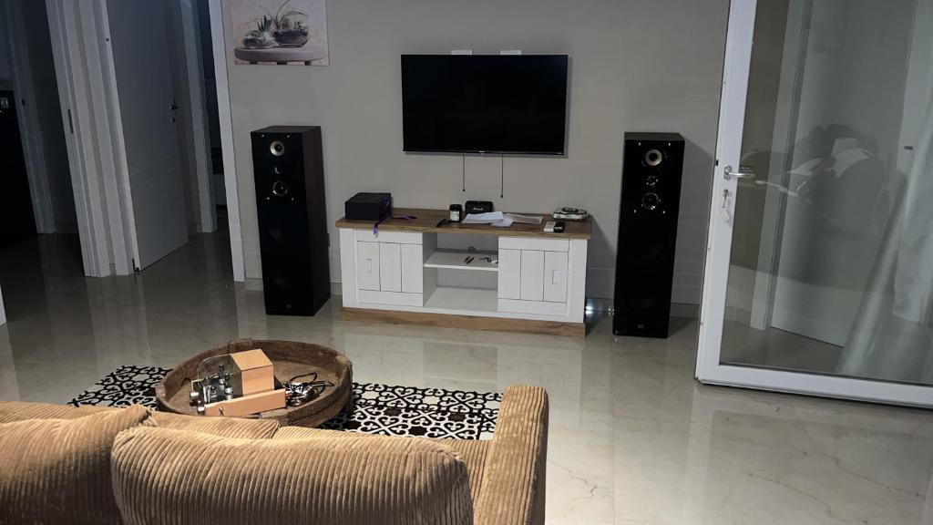 - un salon avec un canapé, une télévision et des haut-parleurs dans l'établissement Villa Bianca, à Galugnano
