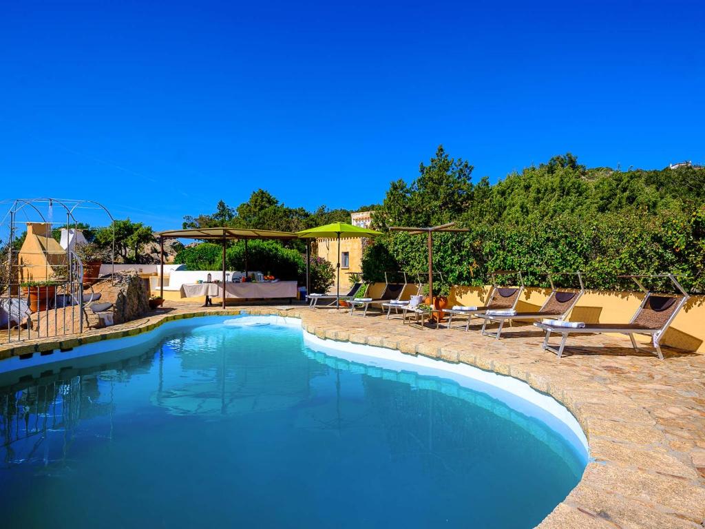 une grande piscine avec des chaises longues dans une cour dans l'établissement Sardinia Family Villas - Villa Nina with private pool, à Abbiadori