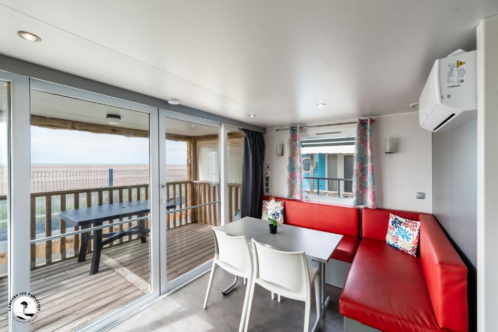 un salon avec un canapé rouge et une table dans l'établissement Camping Les Violettes, à La Faute-sur-Mer