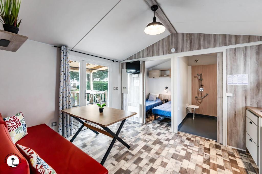 un salon avec un canapé rouge et une table dans l'établissement Camping Les Violettes, à La Faute-sur-Mer 37 autres photos