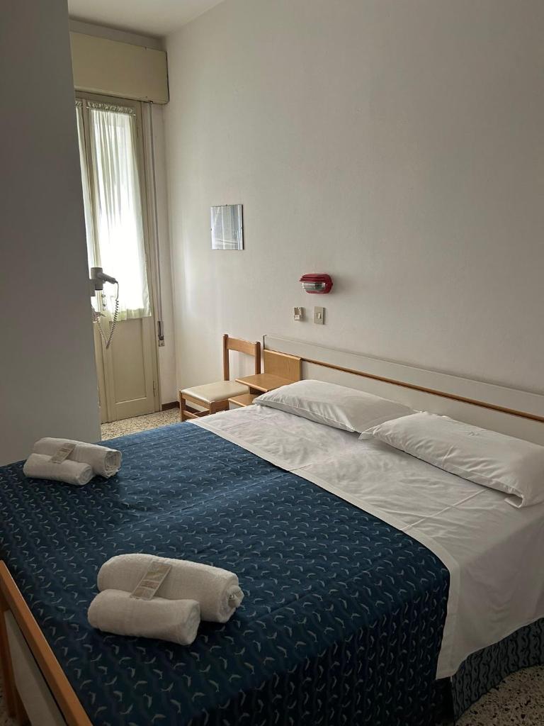 une chambre avec un grand lit avec des serviettes dessus dans l'établissement Camere Capinera, à Cesenatico 8 autres photos