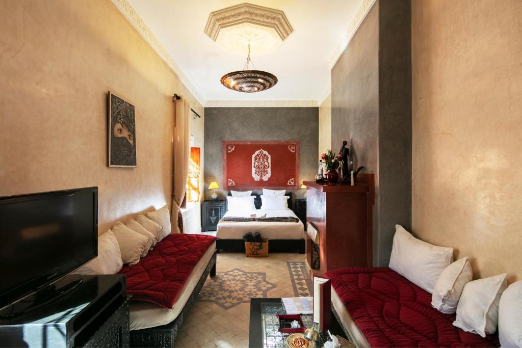 un salon avec un canapé et un lit dans l'établissement Riad Alili, à Marrakech