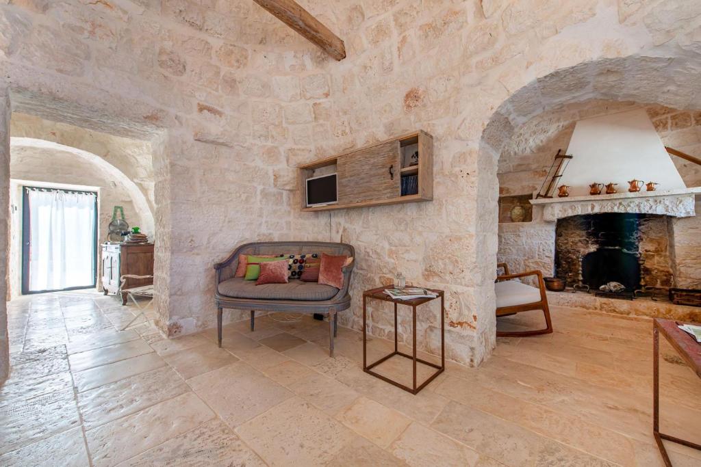 - un salon avec une chaise et une cheminée dans l'établissement Tenuta Diciassetteconi Trulli With Pool, à Ostuni