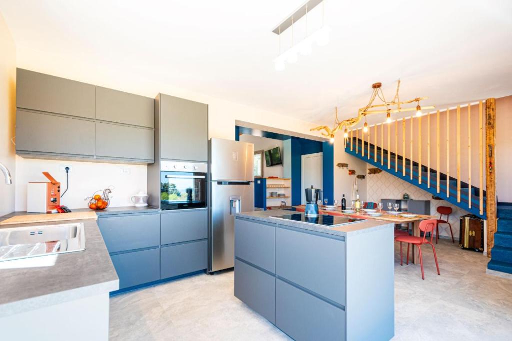une grande cuisine avec des armoires bleues et un escalier dans l'établissement Villa Maguetta with private pool in Scopello, à Scopello