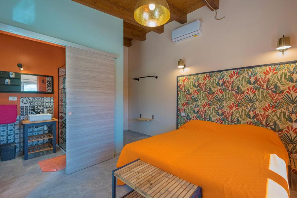 une chambre avec un lit orange et un mur coloré dans l'établissement Villa Maguetta with private pool in Scopello, à Scopello 56 autres photos