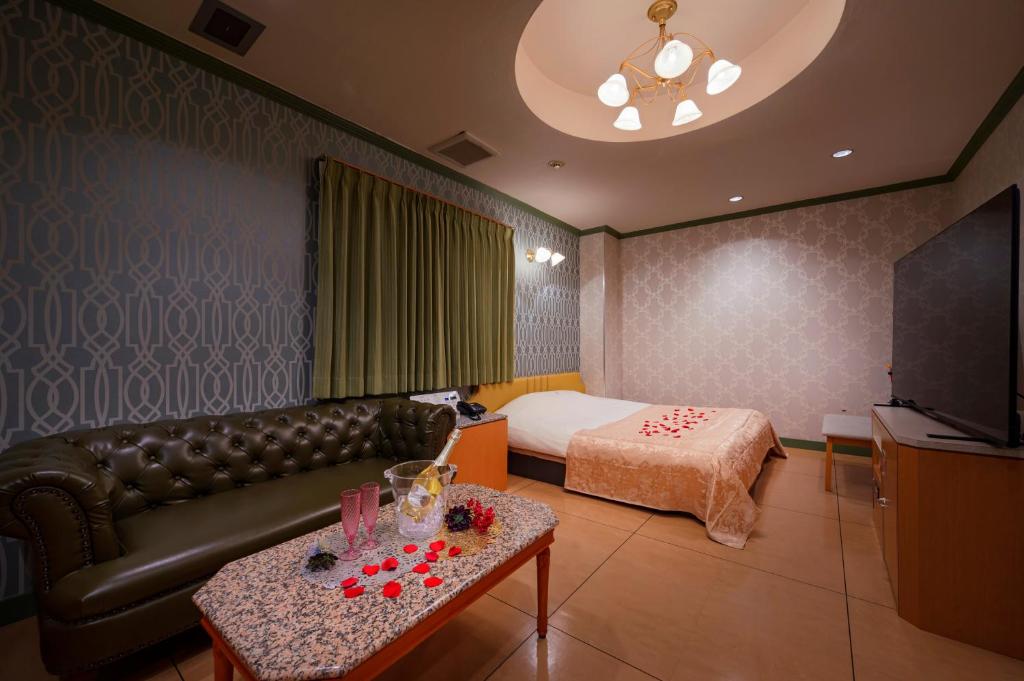 un salon avec un canapé et un lit dans l'établissement Happy Kiss (Adult Only), à Showa