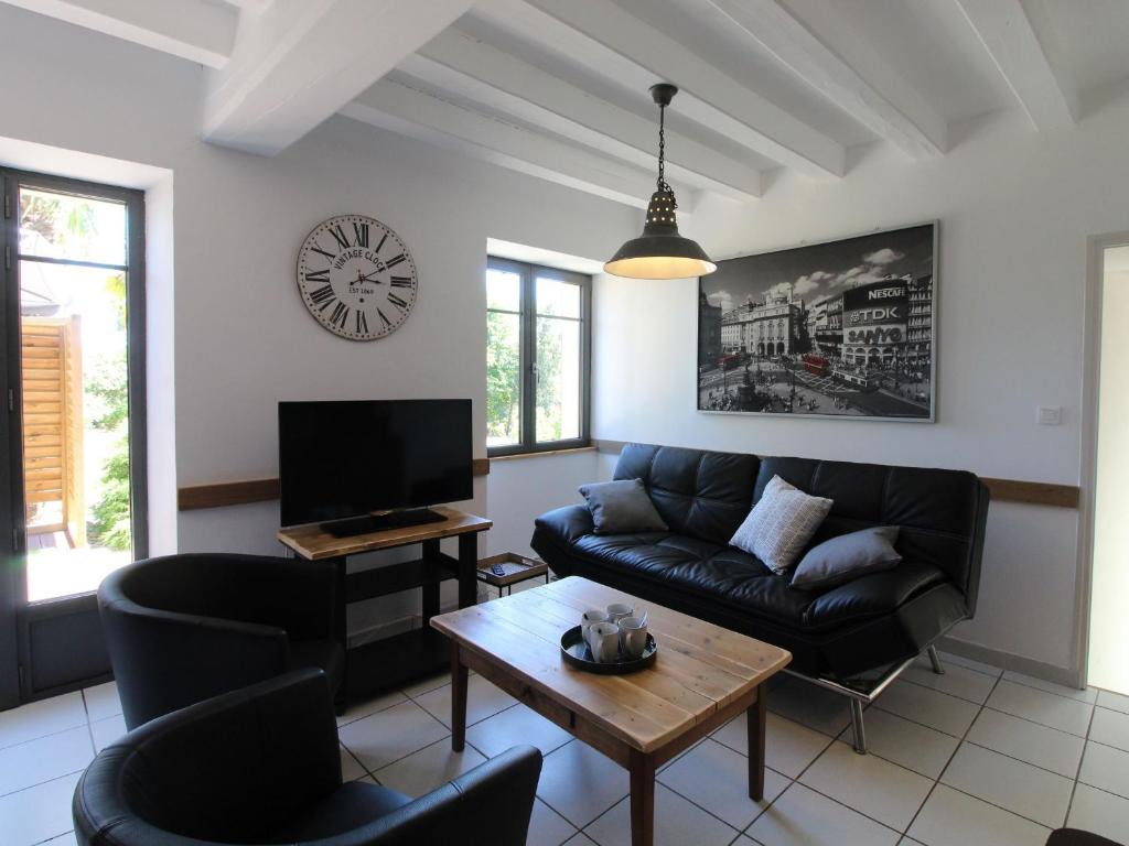 un salon avec un canapé et une table dans l'établissement Gîte moderne avec piscine en Anjou, proche Saumur et Cholet, idéal pour familles et groupes - FR-1-622-30, à Vihiers