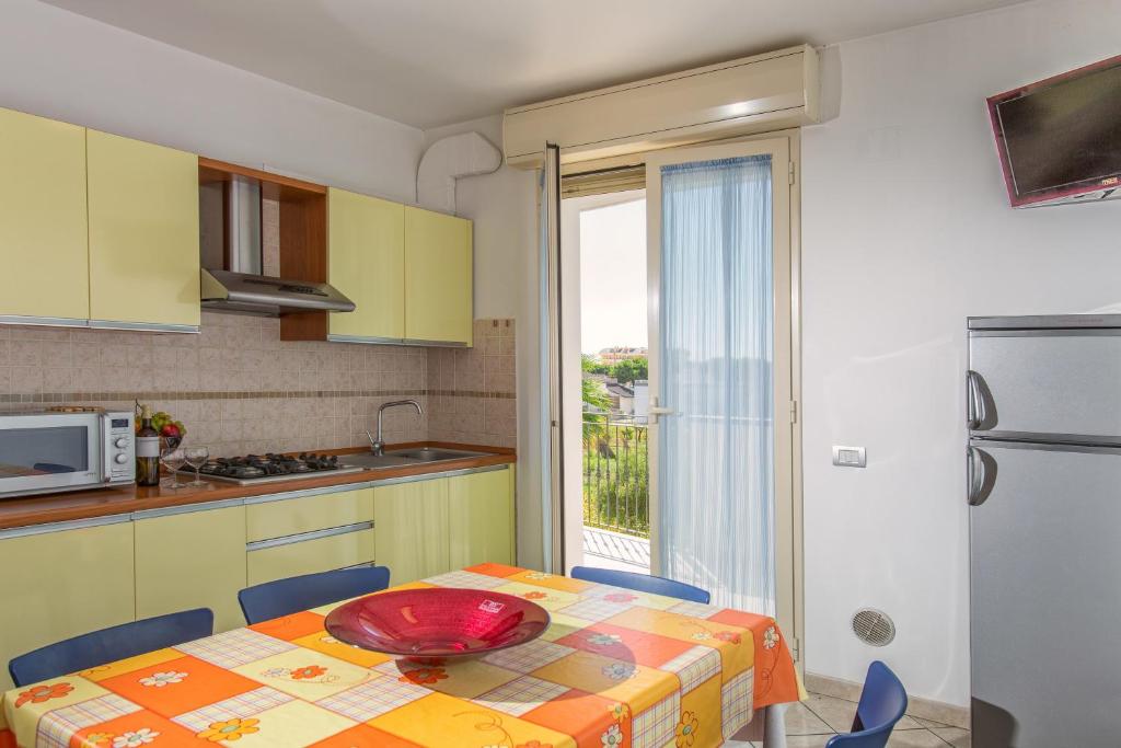 une cuisine avec une table avec une assiette rouge dessus dans l'établissement Residence il Girasole 1, à Alba Adriatica