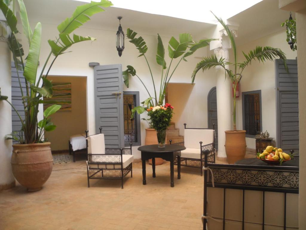 un salon avec une table, des chaises et des plantes dans l'établissement Riad Linda, à Marrakech