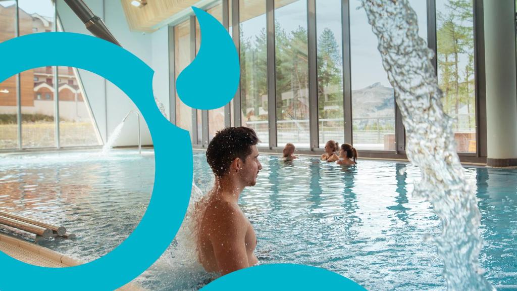 un homme dans une piscine avec un numéro bleu dans l'établissement Superdevoluy545S, 6 places, été et hiver, pied des pistes, plein sud, à Saint-Étienne-en-Dévoluy