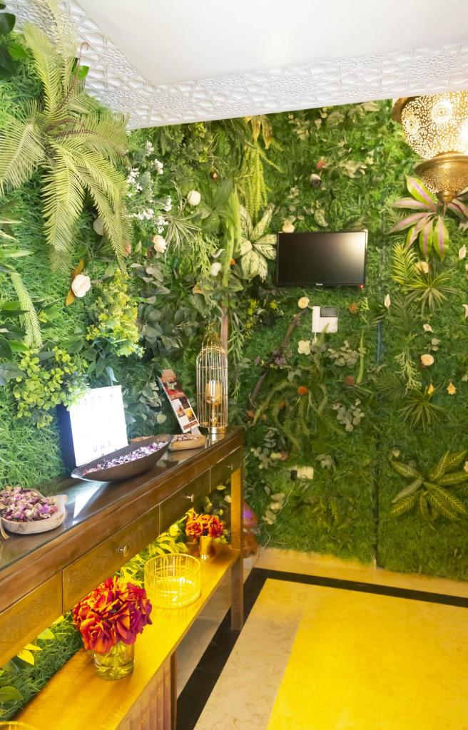 une chambre avec un mur vert recouvert de plantes dans l'établissement Riad La Rose Orientale Marrakech, à Marrakech