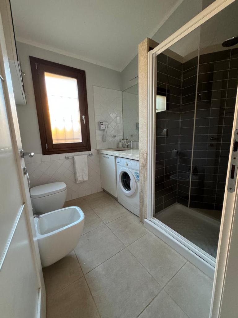 une salle de bain avec toilettes et lavabo et une machine à laver dans l'établissement VILLA AQUA LUXURY Private Pool, à San Teodoro