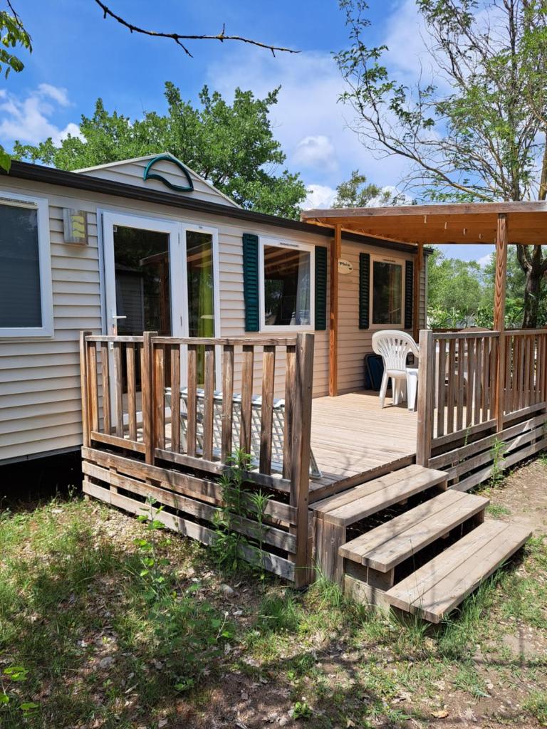 une maison avec une terrasse couverte en bois et une terrasse dans l'établissement Mobile Home 270, à La Roque-dʼAnthéron