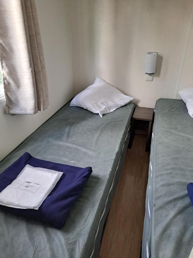 Cette petite chambre comprend 2 lits jumeaux et une fenêtre. dans l'établissement Mobile Home 270, à La Roque-dʼAnthéron 4 autres photos