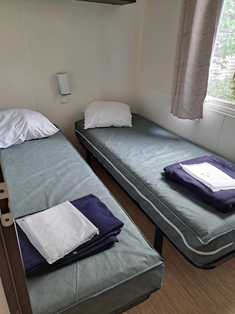 deux lits jumeaux dans une chambre avec fenêtre dans l'établissement Mobile Home 270, à La Roque-dʼAnthéron