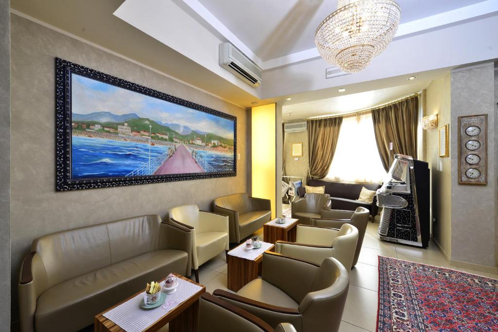 une salle d'attente avec des canapés et un tableau sur le mur dans l'établissement Hotel Villa Tiziana, à Marina di Massa