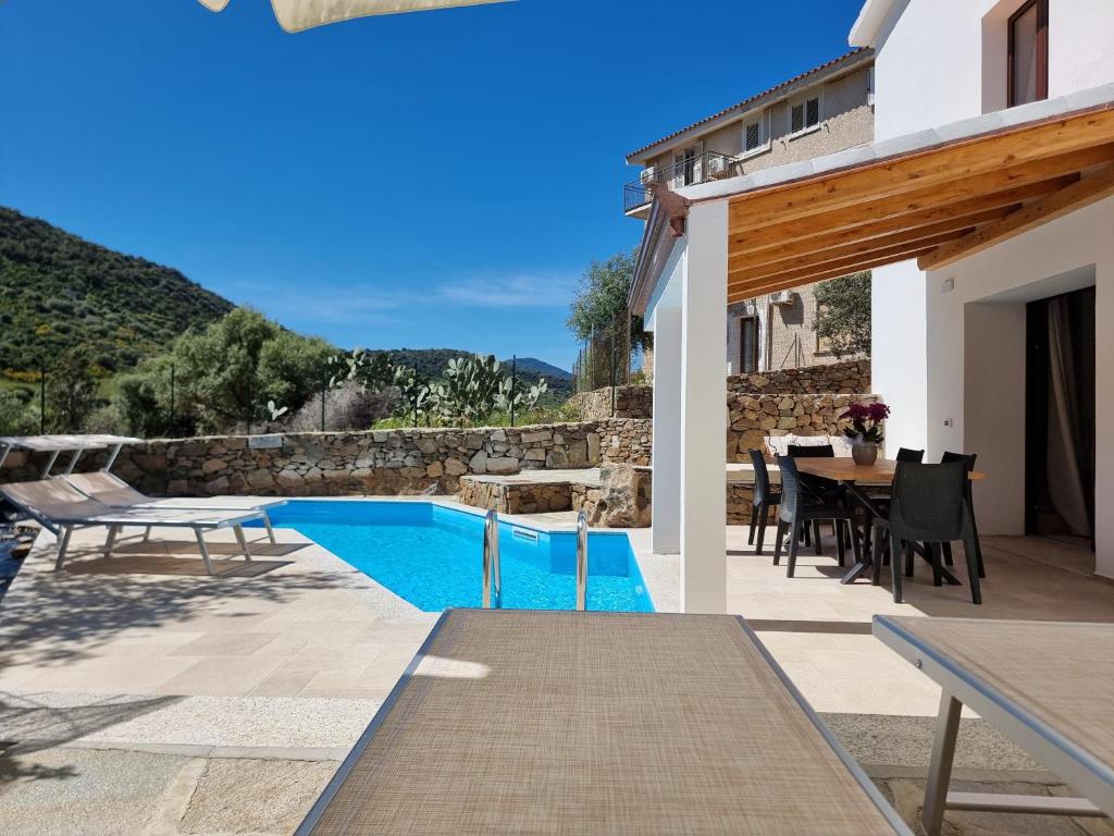 une villa avec une piscine, une table et des chaises dans l'établissement Villetta Roxy, à Tanaunella