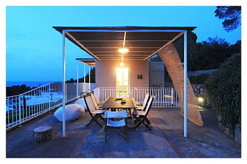 un patio avec une table et des chaises sur une terrasse dans l'établissement Casa Tiberius Capri Retreat, à Capri