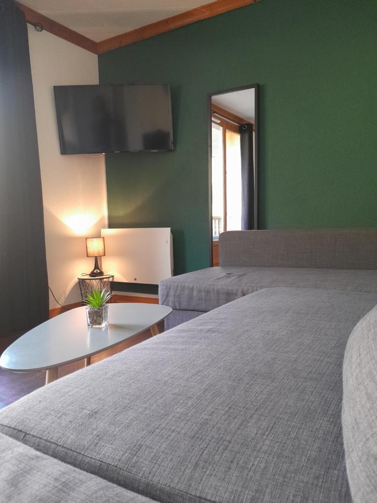 - 2 lits dans une chambre dotée d'un mur vert dans l'établissement T2 confortable - Piscine chauffée - Super Besse, à Besse-et-Saint-Anastaise