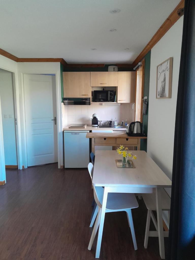 - une cuisine avec une table, une table et des chaises dans l'établissement T2 confortable - Piscine chauffée - Super Besse, à Besse-et-Saint-Anastaise