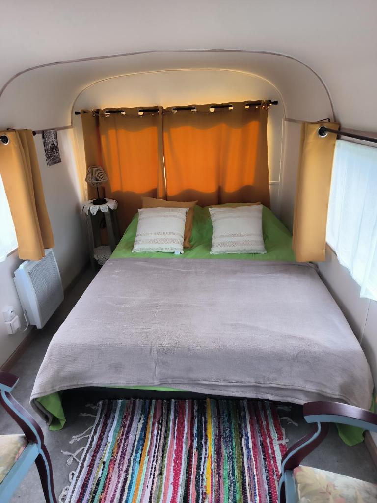 - un lit à l'arrière d'une petite chambre dans l'établissement Roulotte insolite La Marivole, à Azay-le-Ferron