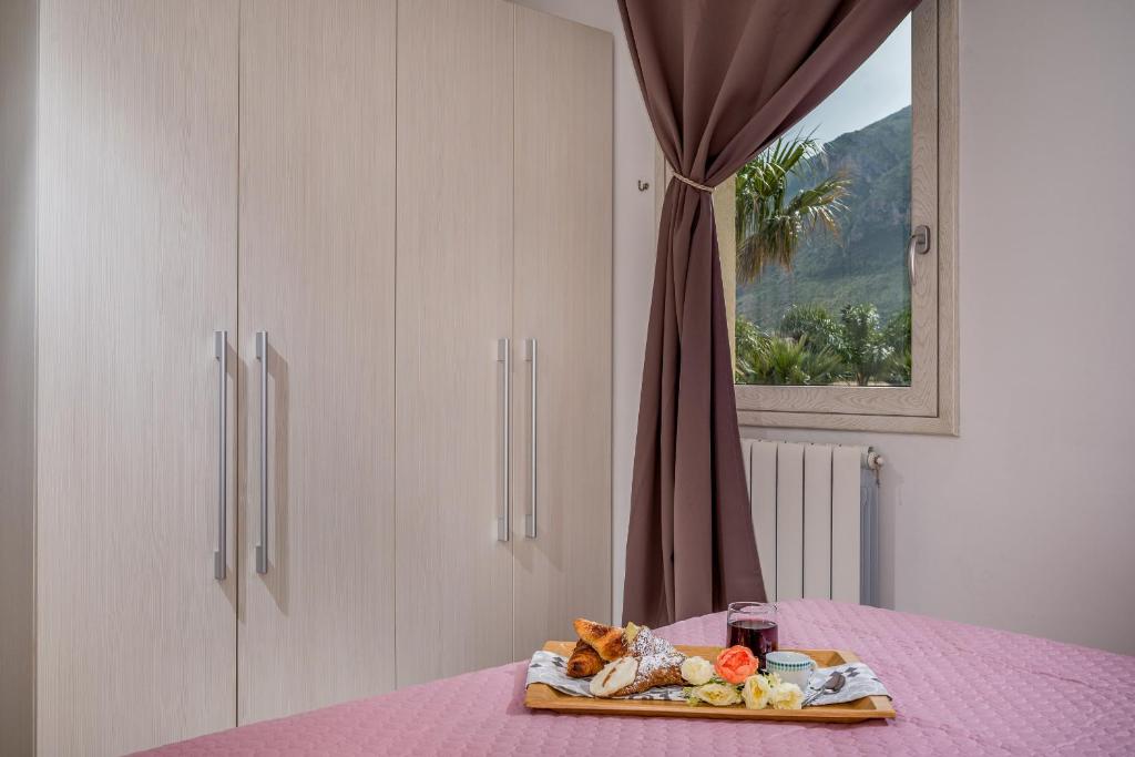 - une table avec un plateau de nourriture sur une table rose dans l'établissement Villa Jacqueline con piscina privata 8 posti letto, à Scopello