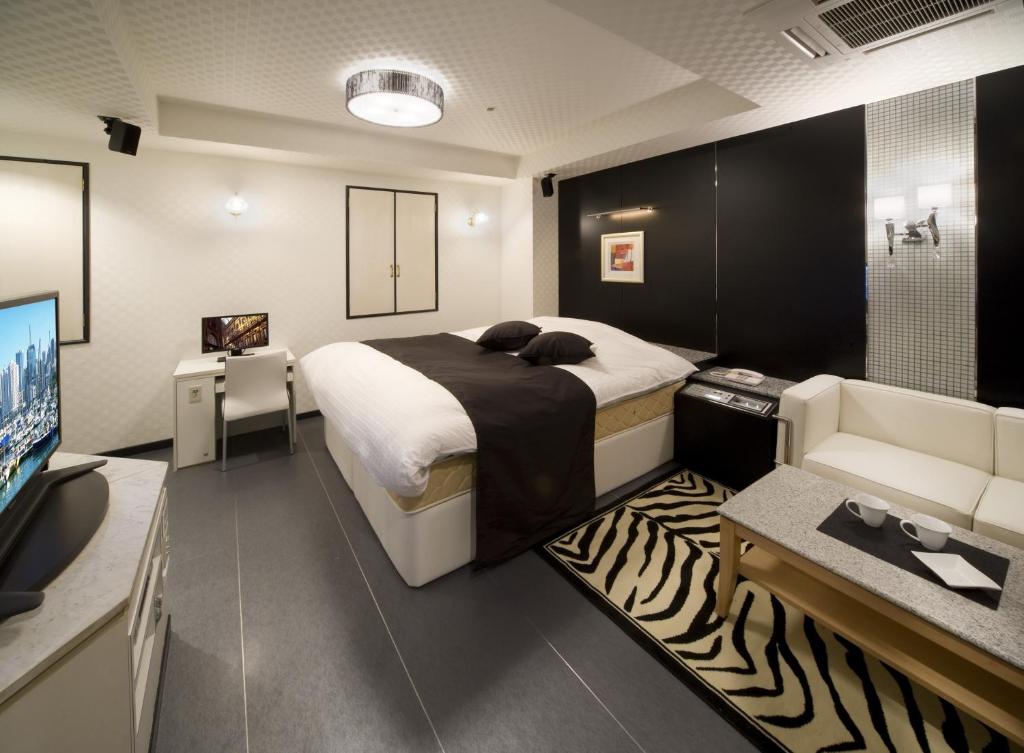 une chambre avec un lit, un canapé et une télévision dans l'établissement HOTEL & SPA ISLAND (Adult Only), à Toyota 16 autres photos