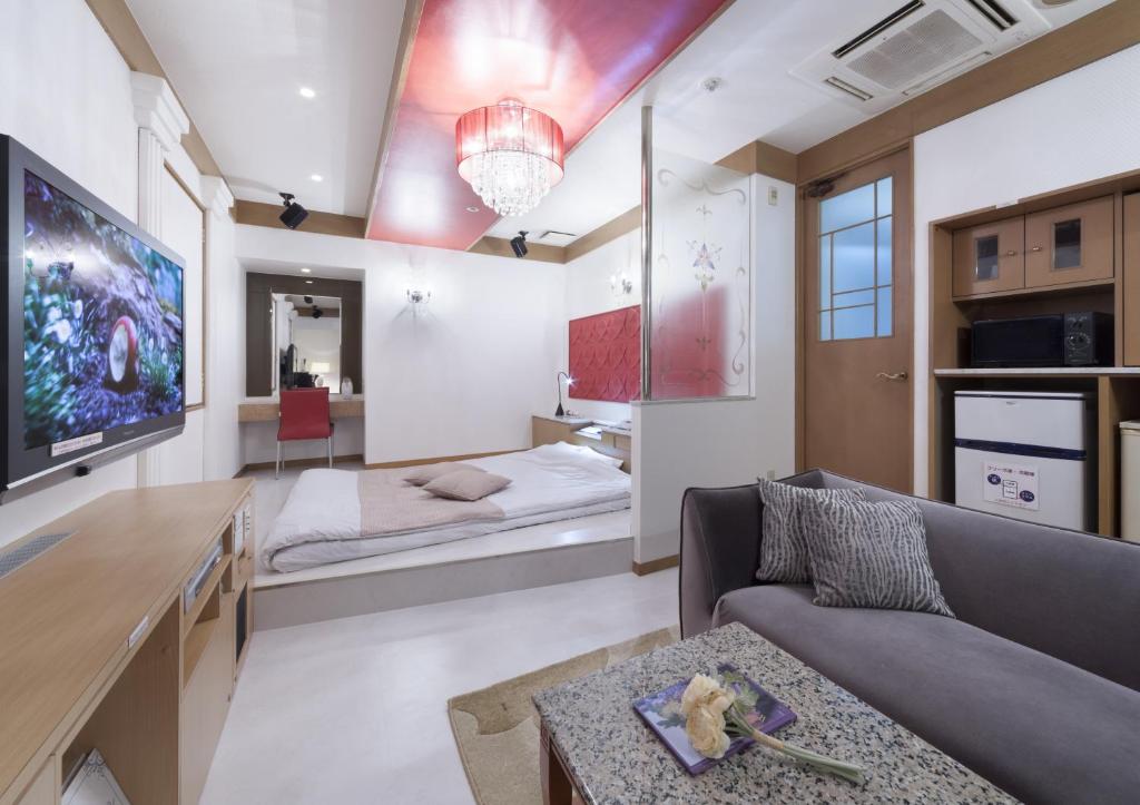 un salon avec deux lits et un canapé dans l'établissement HOTEL & SPA ISLAND (Adult Only), à Toyota