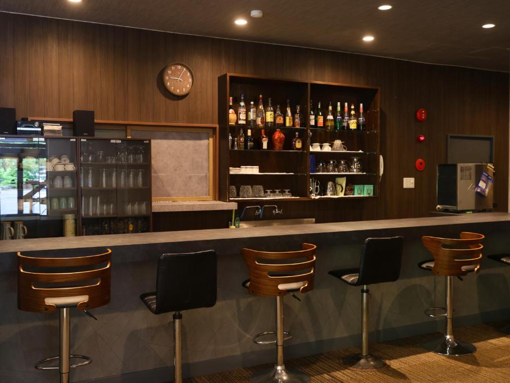 un bar avec des chaises et une horloge au mur dans l'établissement Kamikochi Hotel, à Matsumoto 106 autres photos