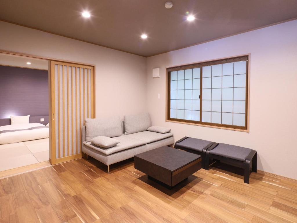 un salon avec un canapé et un lit dans l'établissement Kamikochi Hotel, à Matsumoto
