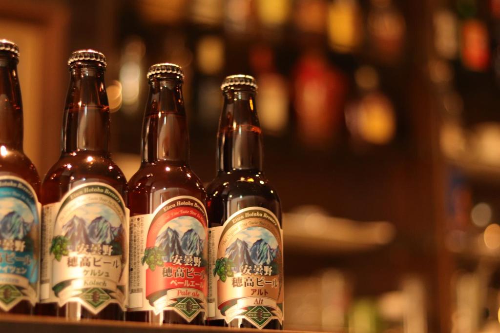 une rangée de bouteilles de bière assise sur une étagère dans l'établissement Kamikochi Hotel, à Matsumoto