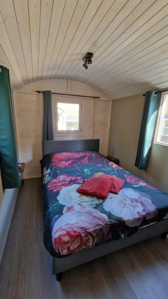 - une chambre avec un lit dans une petite maison dans l'établissement De pipowagens van het Château, à Viviez