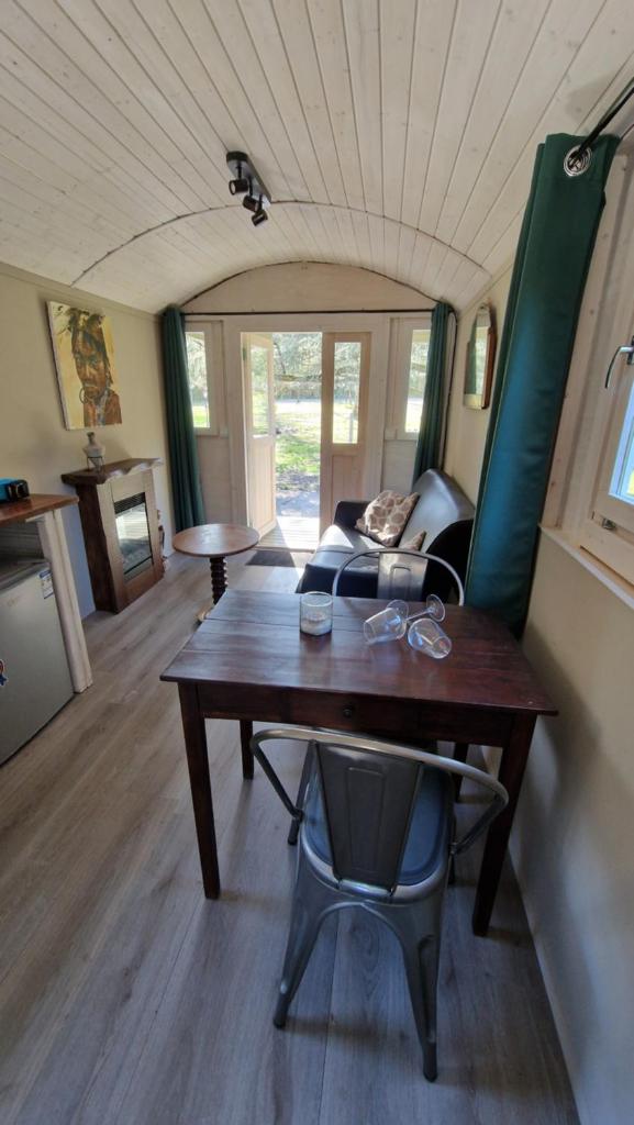 un salon avec une table et un canapé dans l'établissement De pipowagens van het Château, à Viviez