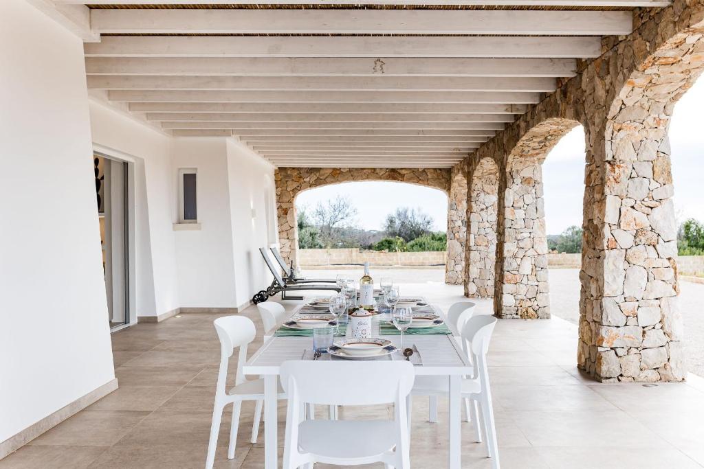 une salle à manger blanche avec une table et des chaises blanches dans l'établissement Villa Caleddha By Vivimy, à Racale