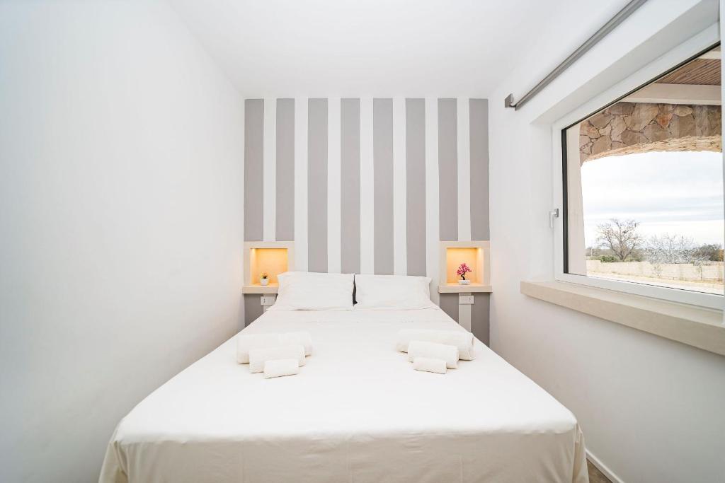 une chambre blanche avec deux lits et une fenêtre dans l'établissement Villa Caleddha By Vivimy, à Racale