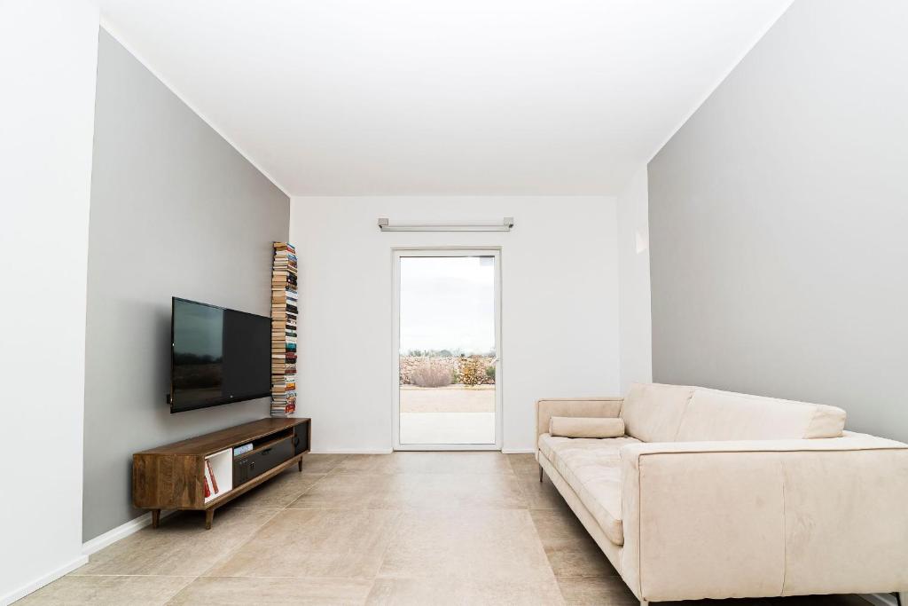 un salon avec un canapé et une télévision dans l'établissement Villa Caleddha By Vivimy, à Racale