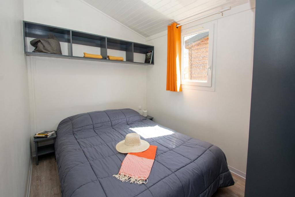 une chambre avec un lit avec un chapeau dessus dans l'établissement A La Rencontre Du Soleil - Camping, au Bourg-dʼOisans 37 autres photos