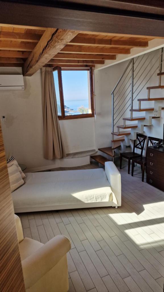 - une chambre avec un lit dans une pièce avec des escaliers dans l'établissement Cala Dei Mori, à Livourne