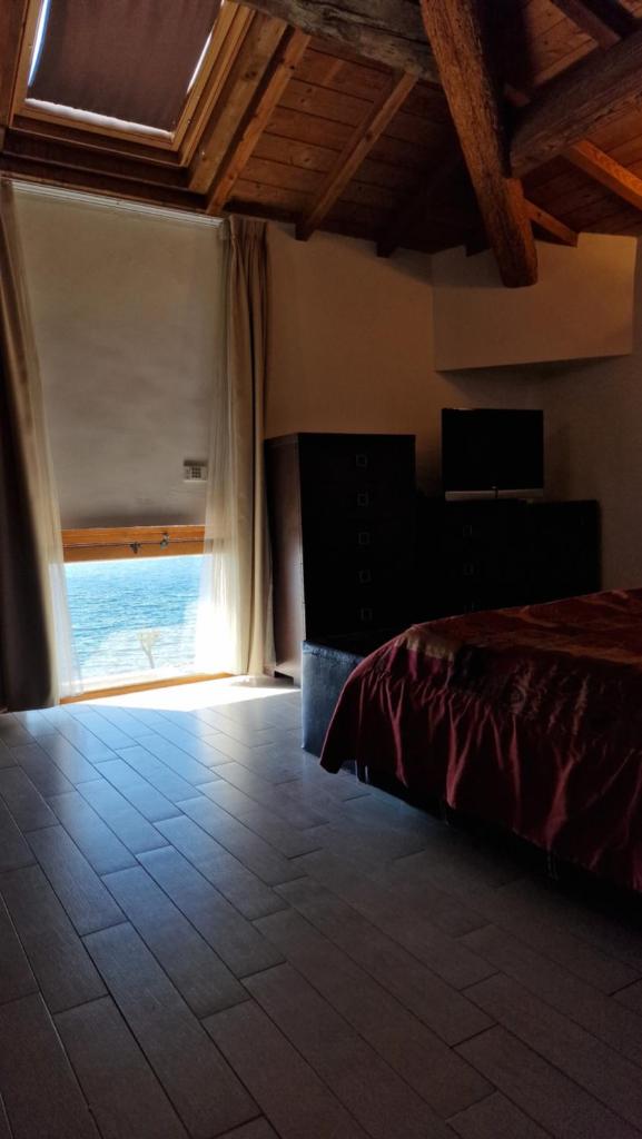 une chambre avec un lit et une grande fenêtre dans l'établissement Cala Dei Mori, à Livourne