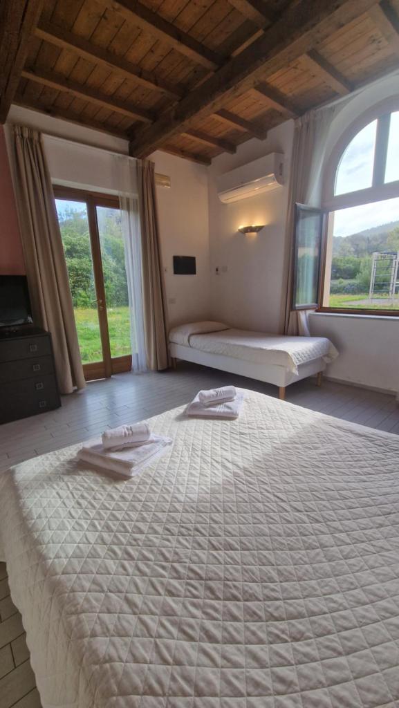 un grand lit dans une chambre à deux lits dans l'établissement Cala Dei Mori, à Livourne